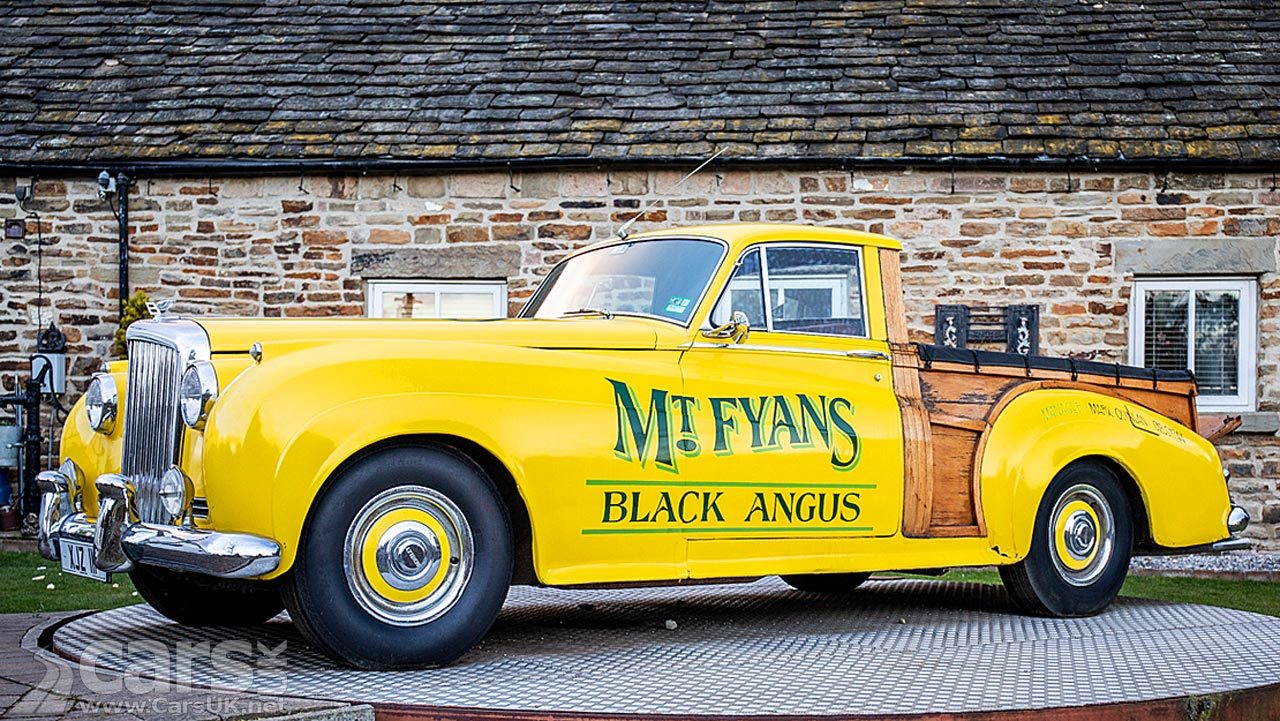 A yellow Bentley S1 Pick-up with wood load bed